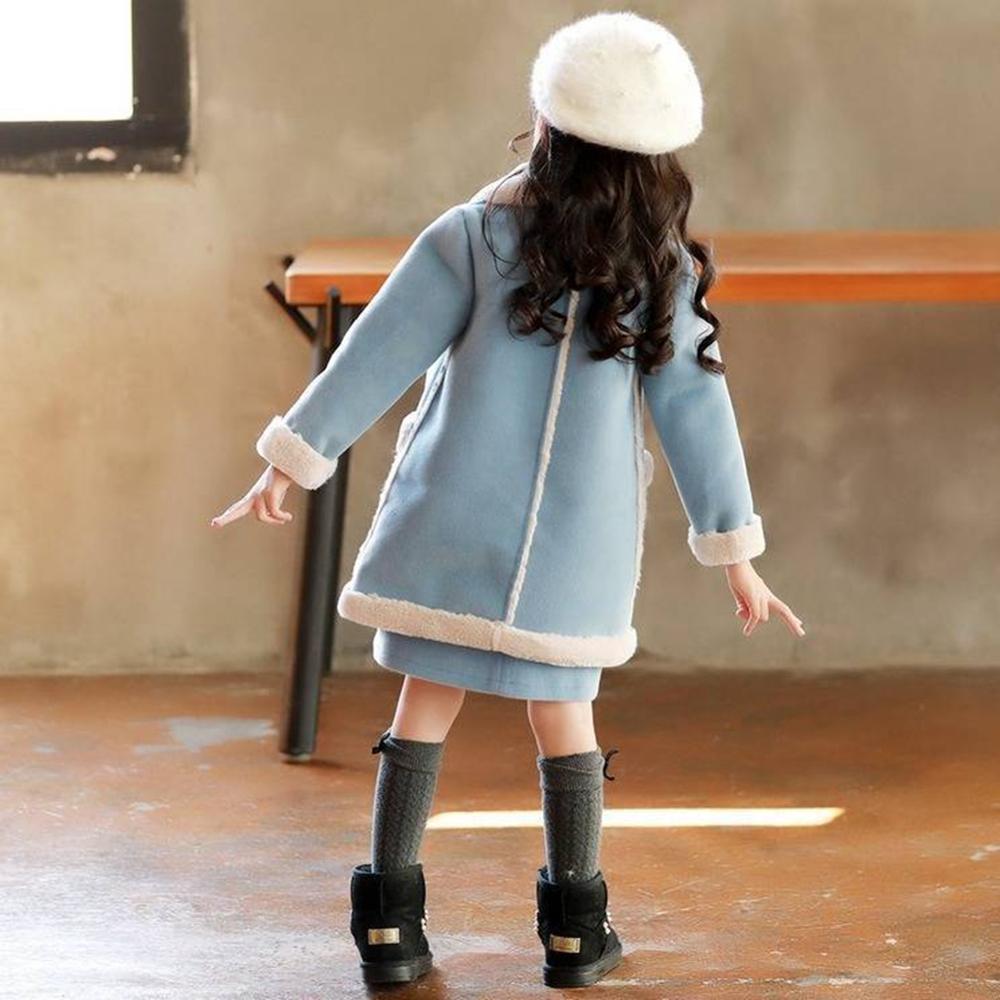 Child in light blue winter coat with white fur trim, matching hat, and black boots