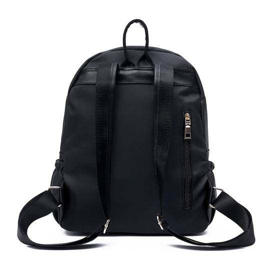 Black nylon backpack with adjustable straps and side zipper pocket, ideal for daily use or travel