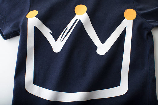 Navy blue t-shirt with white crown graphic and gold dots, stylish fashion apparel