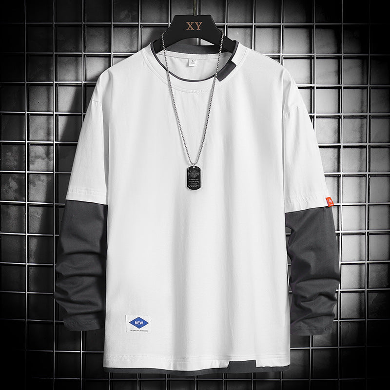 White long-sleeve color-block t-shirt with black sleeves, dog tag necklace, displayed on hanger against grid wall