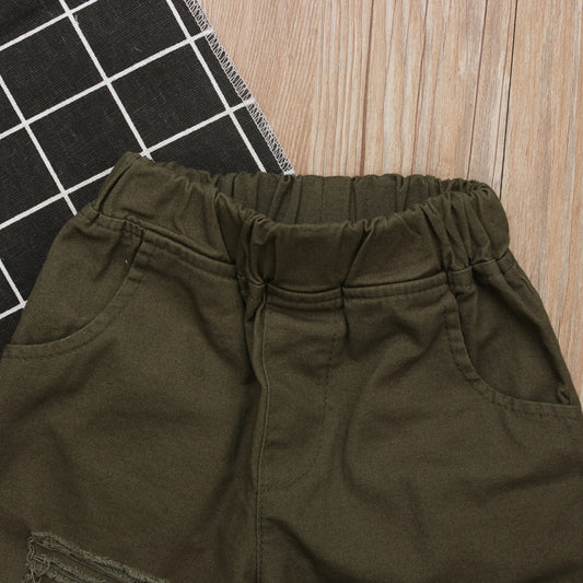 Olive green kids shorts with elastic waistband and side pockets on wood floor