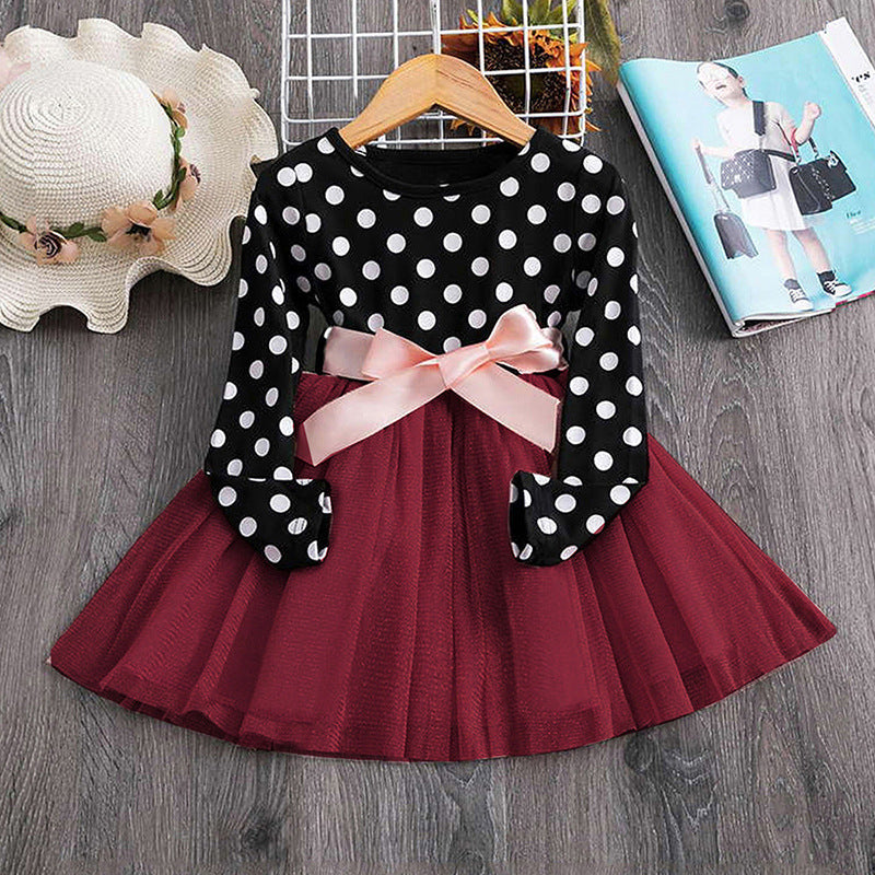 Child wearing a polka dot princess dress from Ancient Energy, with ruffled sleeves and a full skirt, front view.