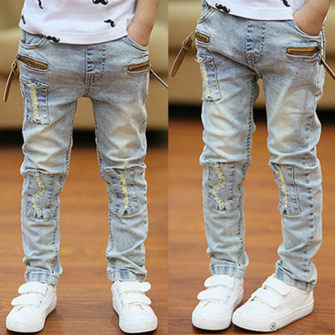 Young boy wearing blue denim trousers from Ancient Energy, casual children's jeans with pockets and adjustable waist.