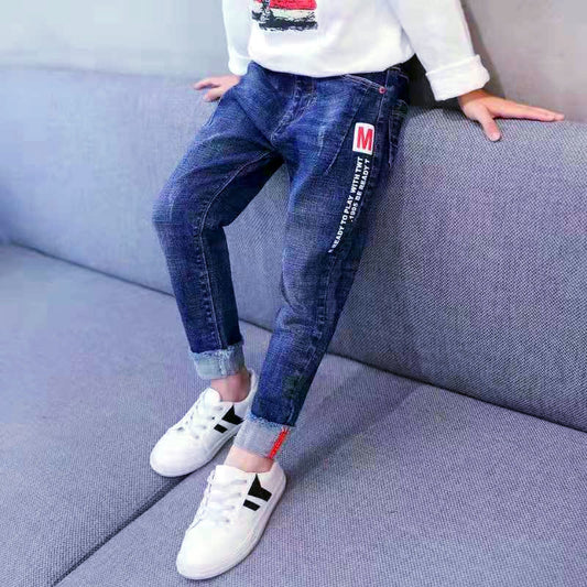 Young boy wearing Ancient Energy velvet winter and autumn jeans, one-piece outfit with a cozy, stylish design for cold weather.