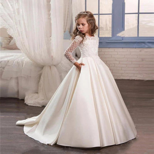Little girl wearing a champagne long sleeve dress by Ancient Energy, soft fabric and elegant style for special occasions.