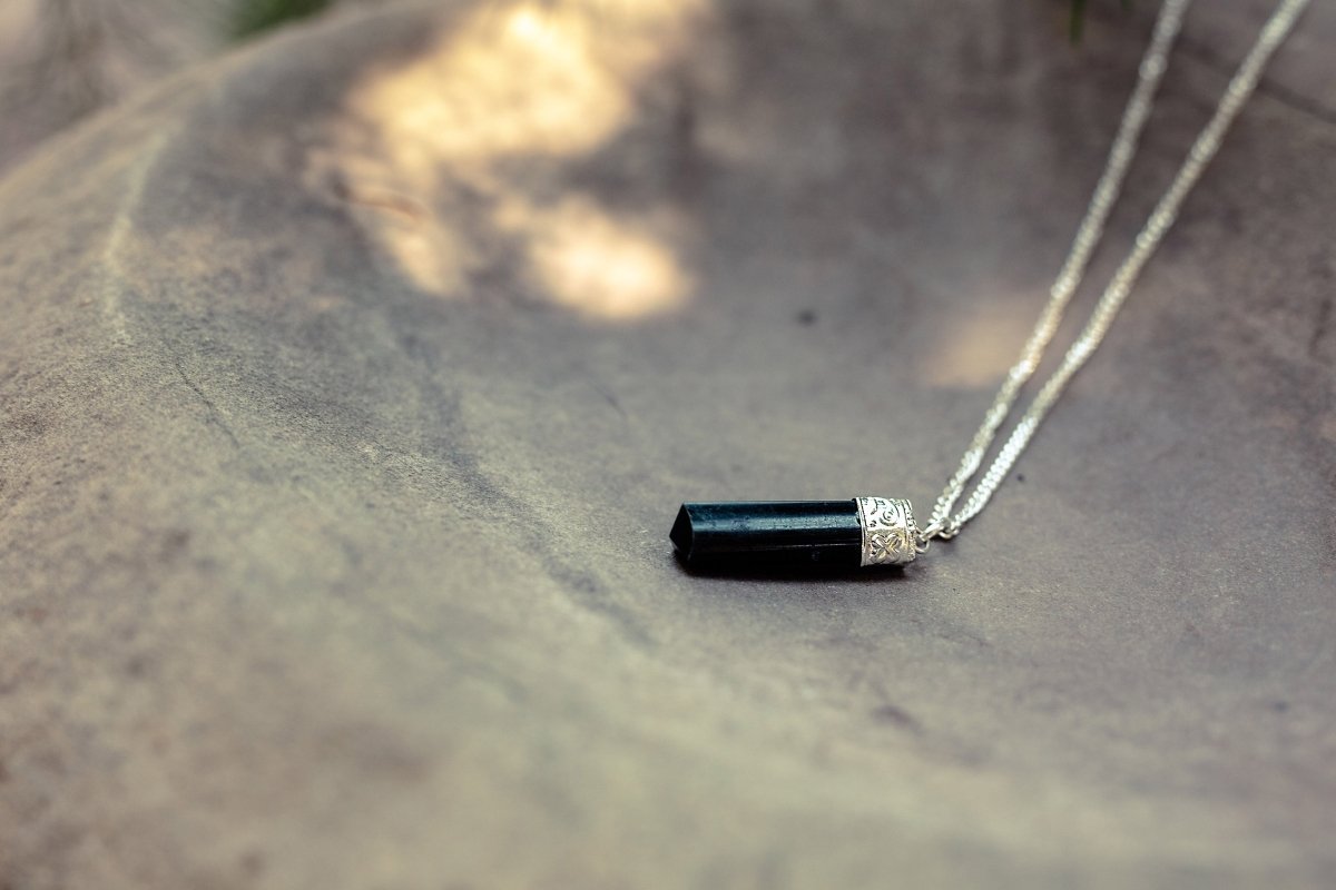 Silver-plated Black Tourmaline Protection Pendant from Ancient Energy, showcasing a polished black tourmaline stone on a silver chain.
