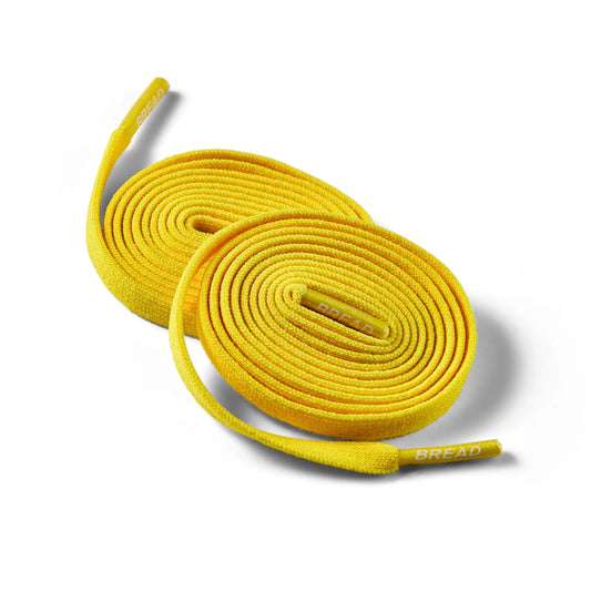 Yellow elastic shoelace by Bread, designed for easy fastening and a comfortable fit, shown in the image.