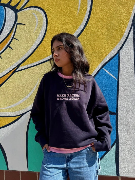 Navy sweatshirt by JZD with anti-racism message, featuring a comfortable fit and bold print on the front.