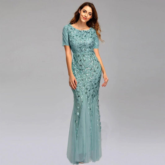 Elegant black evening dress by MANDOTOS, featuring a floor-length gown with a fitted bodice and flowing skirt.