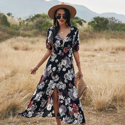 Mandotos floral summer beach dress with V-neck and elastic waist, worn by a woman on the beach in a casual, flowy style.