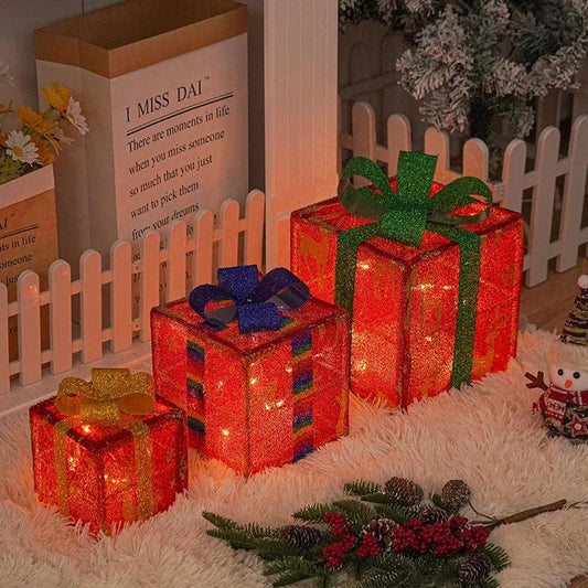 Lighted Christmas gift box decoration with bow by MANDOTOS, perfect for outdoor holiday decor, illuminated with festive lights.