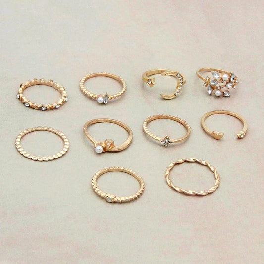 Mandotos Bohemian star, moon, pearl, and leaf rings in a 10-piece gold-finish stackable ring set, featuring intricate designs.