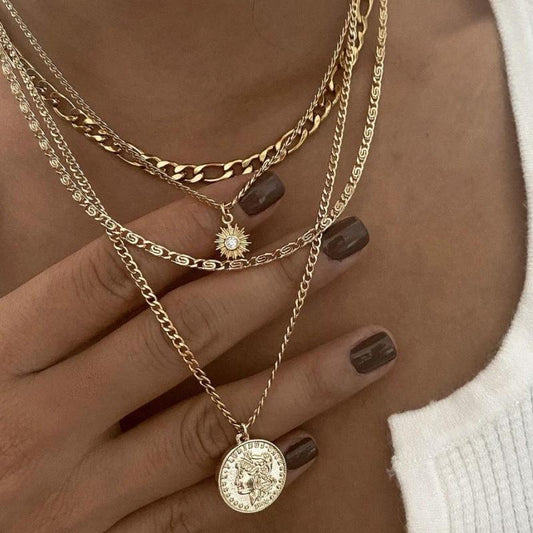 Mandotos chunky gold layered necklace with coin pendant and sun charm for women, featuring multiple chain styles and intricate details.
