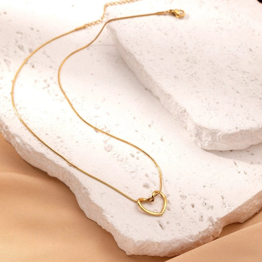 Stainless steel twist hollow heart necklace by MANDOTOS, featuring a delicate clavicle chain with heart pendant.