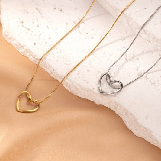 Stainless steel twist hollow heart necklace by MANDOTOS, featuring a delicate clavicle chain with a hollow heart pendant.
