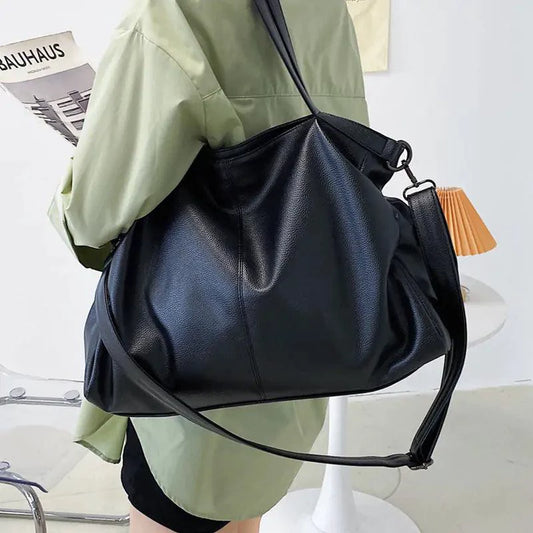 Elegant leather carryall bag by MANDOTOS, featuring a stylish design with sturdy handles and a spacious interior.