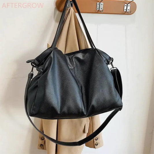 Elegant leather carryall bag by MANDOTOS featuring durable handles and a sleek design for stylish everyday use.