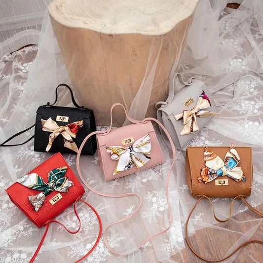 Elegant leather handbag with matching scarf from MANDOTOS, featuring a sleek design and sophisticated accessories.