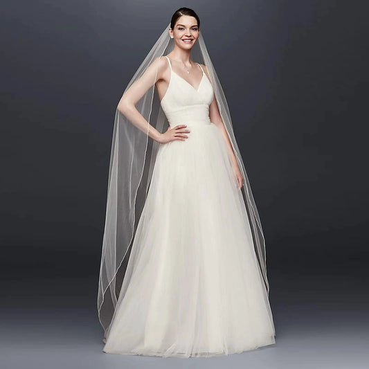 Long flowing veil from ElegantBride V14 collection by MANDOTOS, made of sheer tulle with delicate lace edge for bridal elegance.