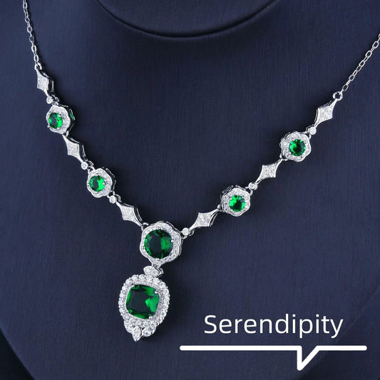 Mandotos Emerald Elegance white gold necklace featuring a central emerald gemstone and delicate chain design.