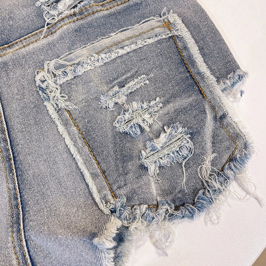 Light-colored raw hem high waist jeans by MANDOTOS, European chic style, shown on a model with casual styling.