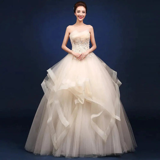 Elegant one-shoulder bridal gown by MANDOTOS INTERNATIONAL with flowing fabric and intricate lace detailing.