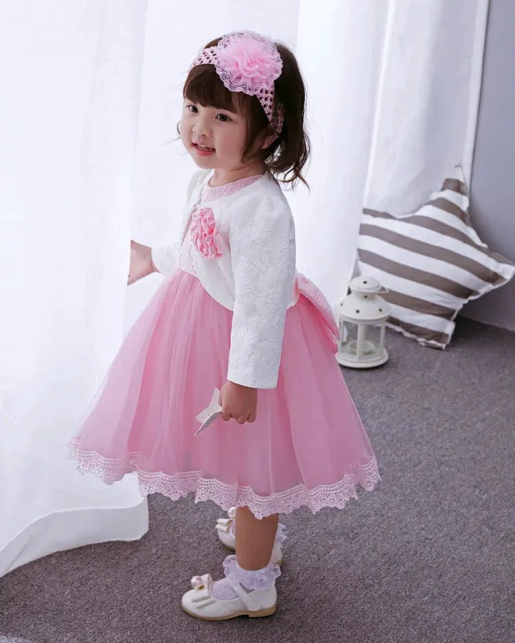 Pink Little Princess gown by MANDOTOS INTERNATIONAL with ruffled sleeves and satin bow, perfect for special occasions.