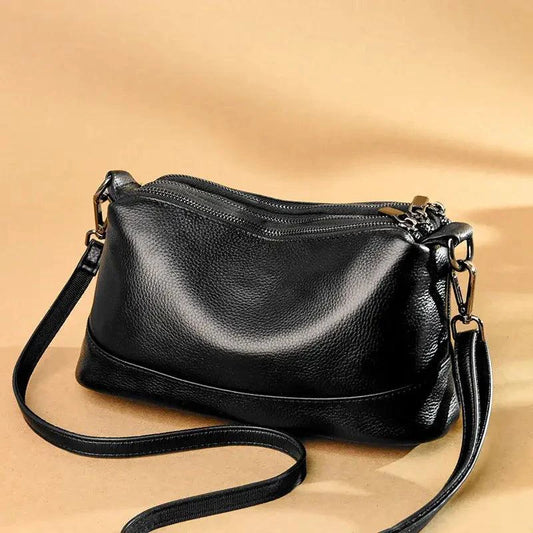 Luxury genuine leather handbag by MANDOTOS featuring a sleek design with top handles and elegant craftsmanship.
