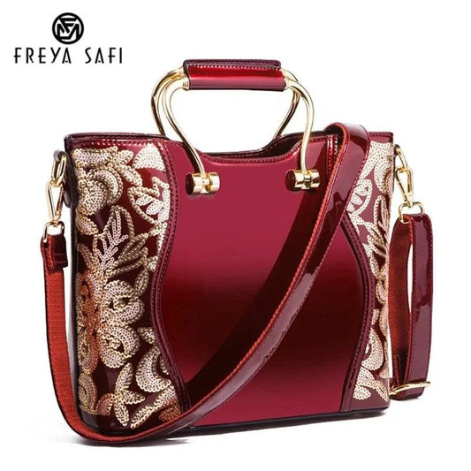 Mandotos elegant floral leather tote in burgundy with embroidered details and a detachable crossbody strap.