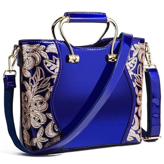 Mandotos elegant floral burgundy leather tote bag with embroidered design and crossbody strap detail.