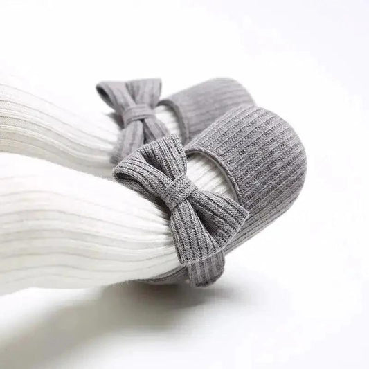 Soft newborn shoes by MANDOTOS featuring plush fabric and tiny soles, perfect for delicate baby feet.