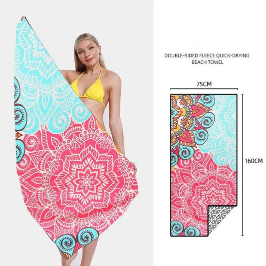 Mandotos SwiftDry patterned beach towel with colorful geometric design laid out on sandy beach.