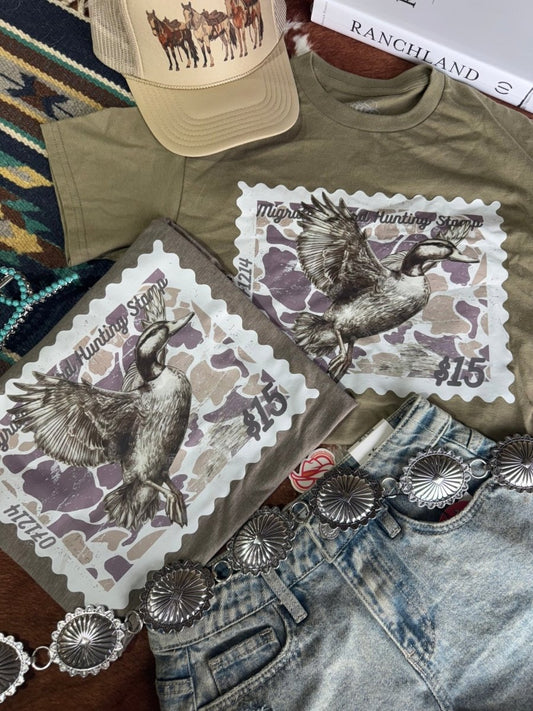 Olive green Duck Stamp graphic tee by Wild Junkie featuring a detailed duck stamp design on a casual graphic tee.