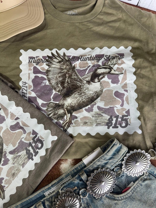 Olive green Duck Stamp graphic tee by Wild Junkie featuring a detailed duck stamp design on a casual men's graphic T-shirt.