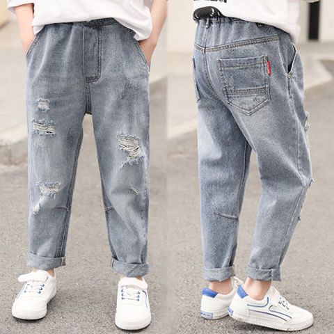 Kids' distressed denim jeans with ripped details, cuffed hems, and white sneakers for casual fashion