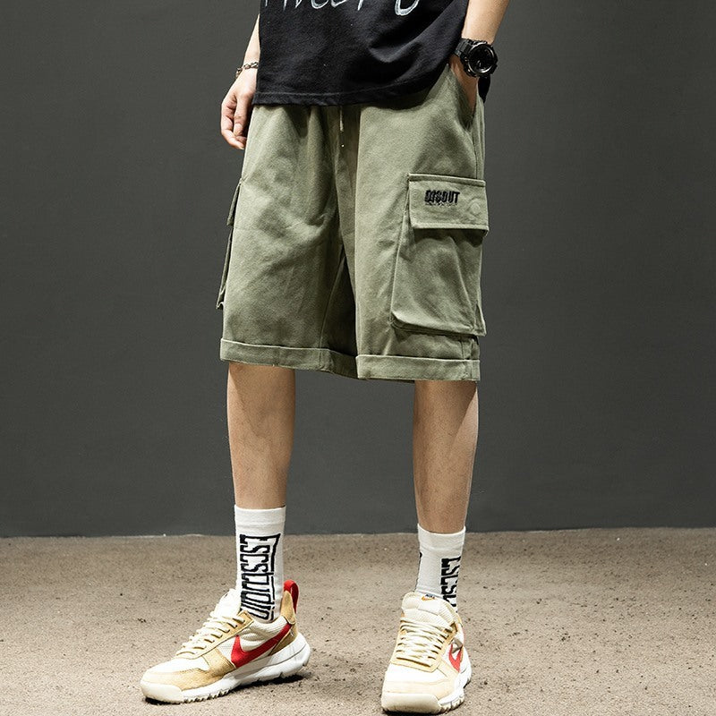 Men's olive cargo shorts with pockets, paired with graphic socks and sneakers for casual streetwear style