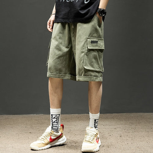 Men's olive cargo shorts with pockets, paired with graphic socks and sneakers for casual streetwear style
