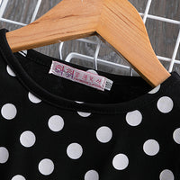 Black and white polka dot top on wooden hanger, fashion classic label