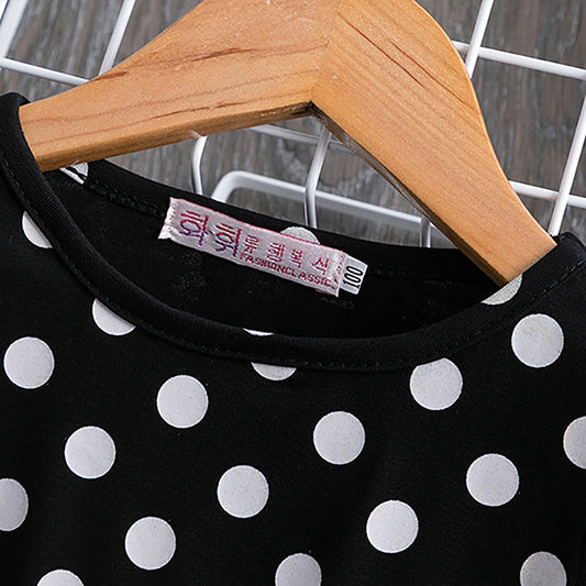 Black and white polka dot top on wooden hanger, fashion classic label
