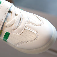 White kids sneaker with green accents, velcro strap, breathable perforations, perfect for casual wear