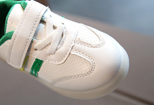 White kids sneaker with green accents, velcro strap, breathable perforations, perfect for casual wear