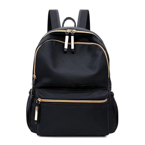 Black backpack with gold zippers, sleek design for fashion and travel