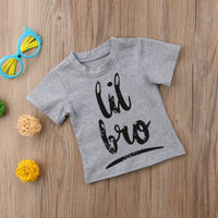 Gray toddler t-shirt with 'lil bro' print, kids fashion, playful design on wood background