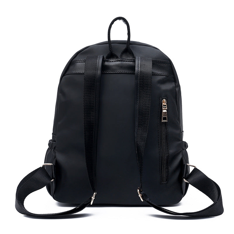 Black nylon backpack with adjustable straps and side zipper pocket, ideal for daily use or travel