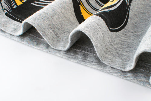 Gray graphic t-shirt with bold black and yellow print, soft cotton fabric detail