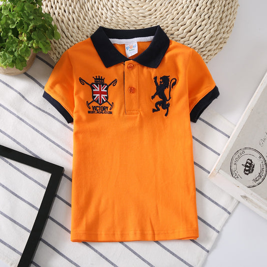 Orange kids polo shirt with lion and UK flag embroidery, black collar and cuffs, striped background