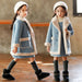 Girls in cozy blue winter coats with faux fur trim, matching hats, and black boots