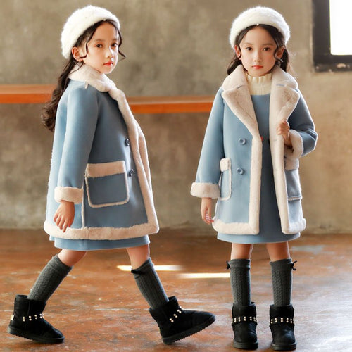 Girls in cozy blue winter coats with faux fur trim, matching hats, and black boots