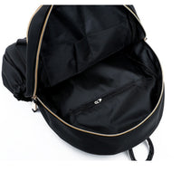 Black backpack interior with gold zipper and front pocket, ideal for fashion accessories and daily essentials