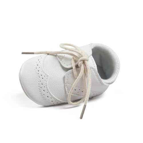 White baby shoes with lace-up design, soft sole for infants, perfect for first steps and special occasions
